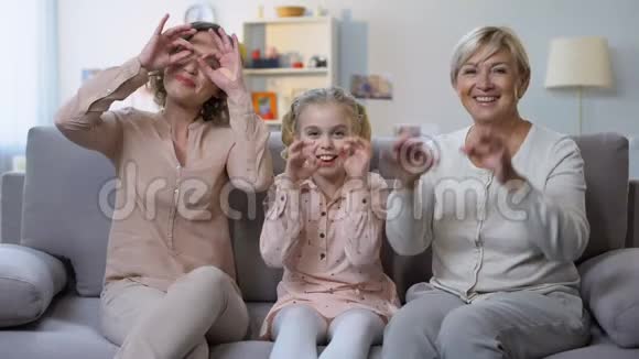 孩子与母亲和奶奶做滑稽的脸手势护目镜有趣视频的预览图