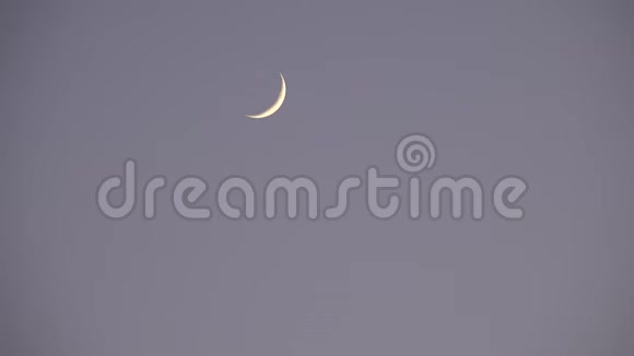半月在云层中升起笼罩天空黄昏的光景黄昏的背景视频的预览图