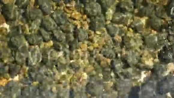 干净的圆形石头在水晶水中清晰可见上面是干净的水晶水和灰色的黄色卵石视频的预览图