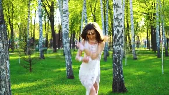 穿着性感裙子在白桦林阳光下跳舞的漂亮女人视频的预览图