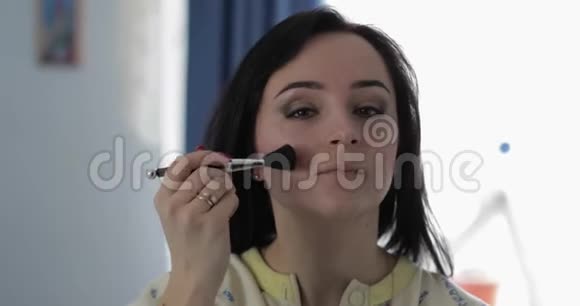 年轻漂亮的女人穿着睡衣靠近镜子美容和化妆概念视频的预览图