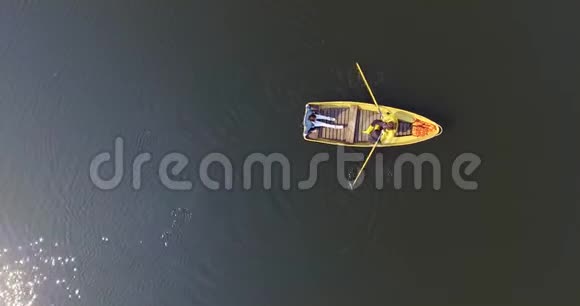 两个人在小船上划船穿过一个美丽的宽阔的反光湖或河积极的生活方式与视频的预览图