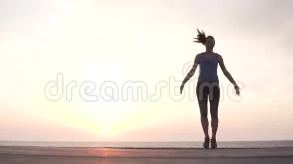 一个可爱的女孩在公园里做跳跃运动和有氧运动视频的预览图