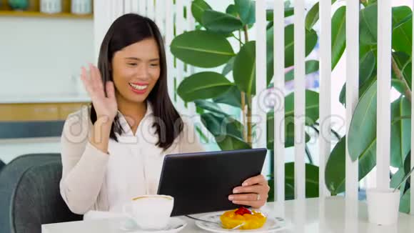 在咖啡馆的平板电脑上有视频通话的亚洲女人视频的预览图