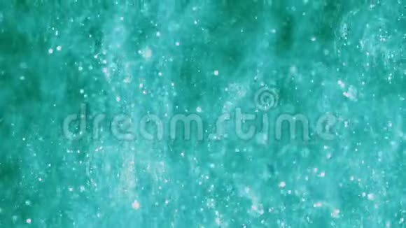 明亮的绿松石背景上有闪亮的颗粒神奇的蓝色在水中闪闪发光抽象背景可用作视频的预览图