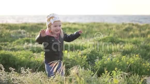 一个小女孩走在海边她跳起来笑了视频的预览图