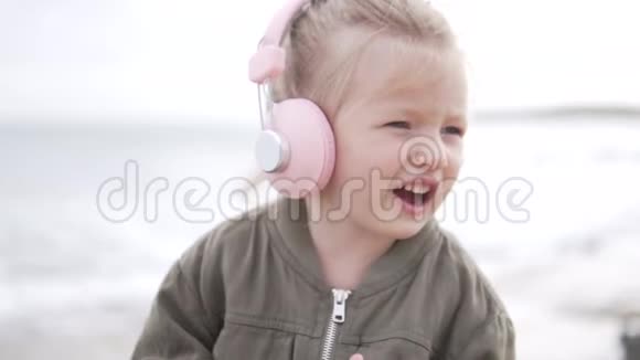 时尚宝宝戴粉色耳机听音乐视频的预览图