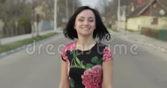 一位漂亮的年轻女子穿着一件连衣裙带着鲜花走向镜头微笑着视频的预览图
