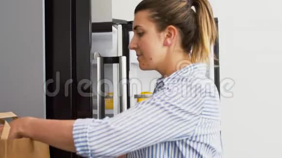 女人把新买的食物放在家里的冰箱里视频的预览图