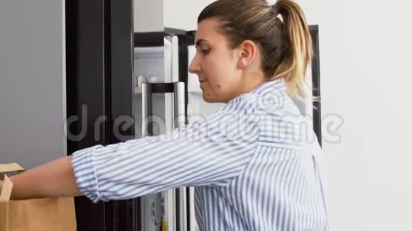 女人把新买的食物放在家里的冰箱里视频的预览图