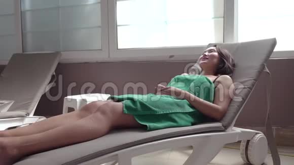 一个年轻的女人在一个土耳其浴室里躺在一个阳光休息室里视频的预览图