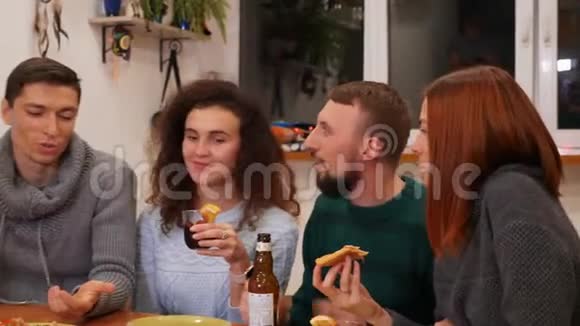 快乐的朋友在家里聊天吃披萨喝酒庆祝新年晚会视频的预览图