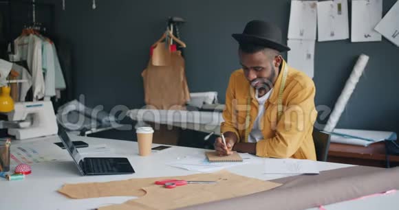 一个美国黑人设计师独自在工作室里写笔记本视频的预览图