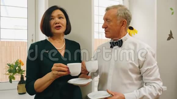 两个拿着茶杯的退休老人谈话视频的预览图