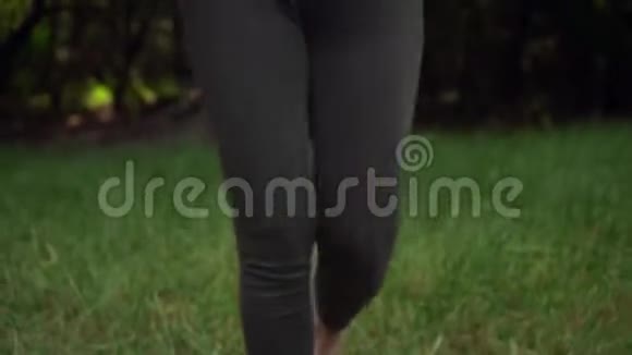做瑜伽的孕妇一个女孩手里拿着一块地毯走路然后把地毯扔到草地上开始练习视频的预览图
