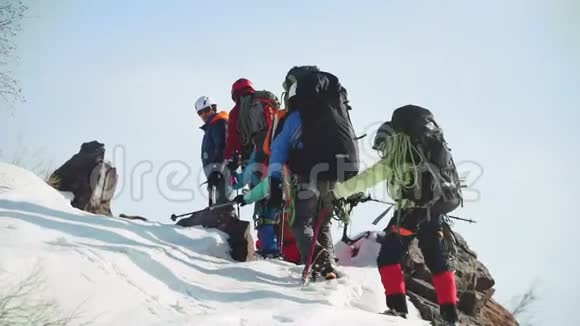 一群游客爬上一座小岩石山特写后视视频的预览图
