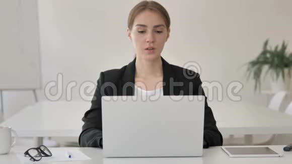 戴头巾的年轻女商人在笔记本电脑上工作视频的预览图