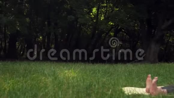 孕妇在公园里用地毯做瑜伽双腿伸直做脚的热身视频的预览图