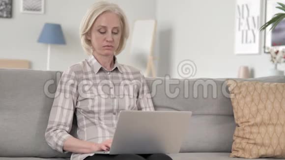 生病的老女人咳嗽和在笔记本电脑上工作视频的预览图