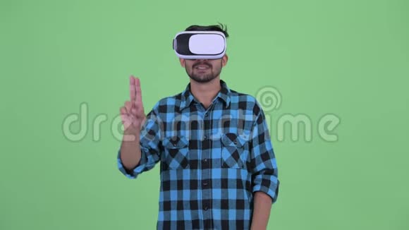 快乐年轻的留着胡子的波斯时髦男人使用虚拟现实耳机视频的预览图
