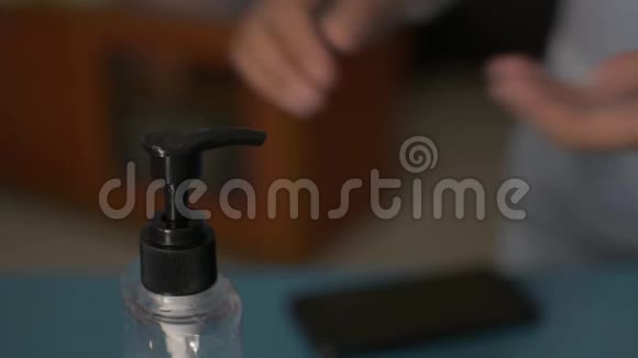 在COVID19爆发期间一名妇女在使用手机前将洗手液注射到手中并对其进行消毒视频的预览图