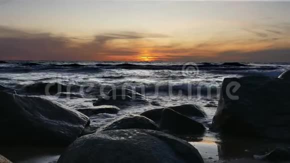 日落时海浪撞击大石头视频的预览图