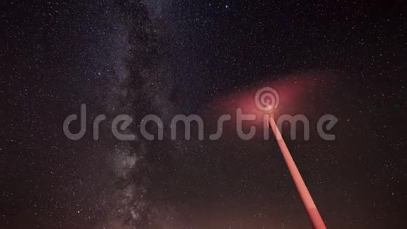 风力涡轮机的夜间时间推移产生清洁能源与银河系的背景视频的预览图