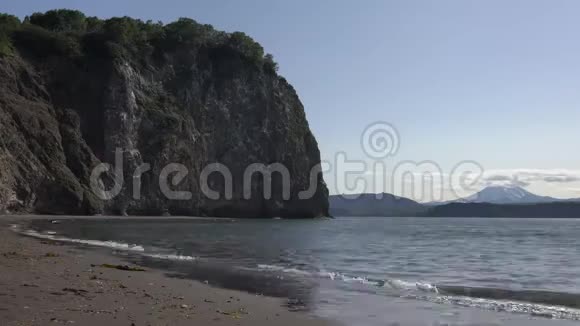 平静的海浪在海上海滩从黑沙岩石海岸太平洋时间流逝视频的预览图