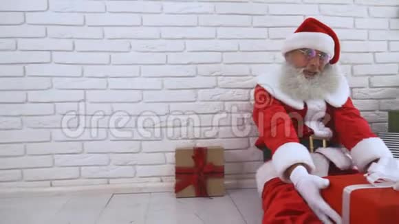 穿着传统服装送红色礼盒的圣诞老人视频的预览图