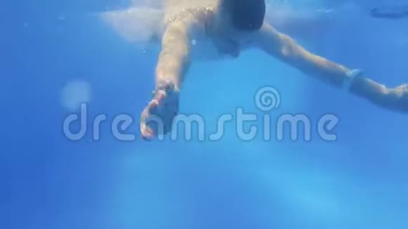 穿着潜水服的人在水下游泳男孩游到镜头前水下射击一个留着长发的男人潜水视频的预览图