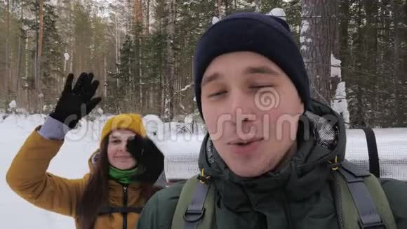 一个年轻人一个视频博主正在和他的女朋友在森林里录制一段视频视频的预览图