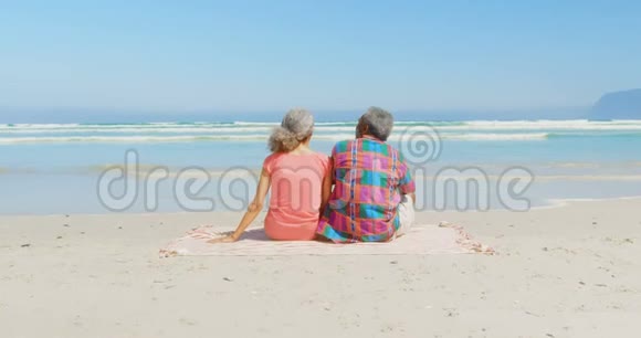 活跃的非裔美国人夫妇在海滩4k阳光下的毯子上放松的后景视频的预览图