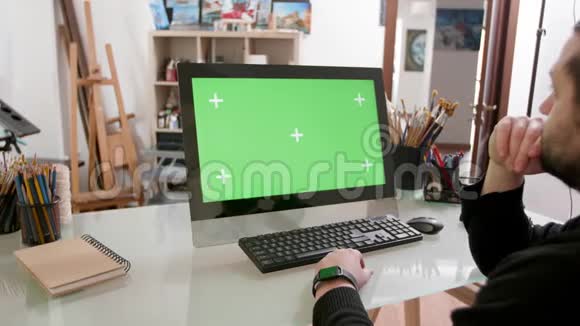 在一个画家工作室里男人专注于绿色的屏幕视频的预览图