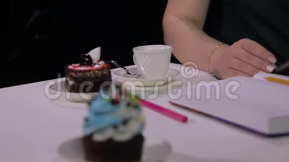 咖啡屋里的一个女人喝咖啡咖啡是白色的杯子背景是黑色的从手到面转移注意力视频的预览图