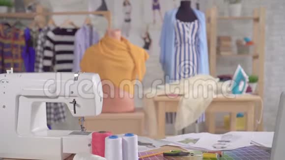 一位时装设计师工作室桌子上的缝纫机和缝纫用品视频的预览图