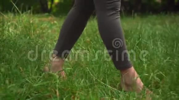 做瑜伽的孕妇一个女孩手里拿着一块地毯走路然后把地毯扔到草地上开始练习视频的预览图