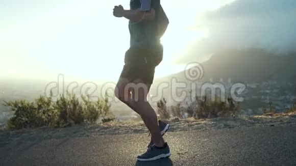 男跑运动员在旭日前伸展腿视频的预览图