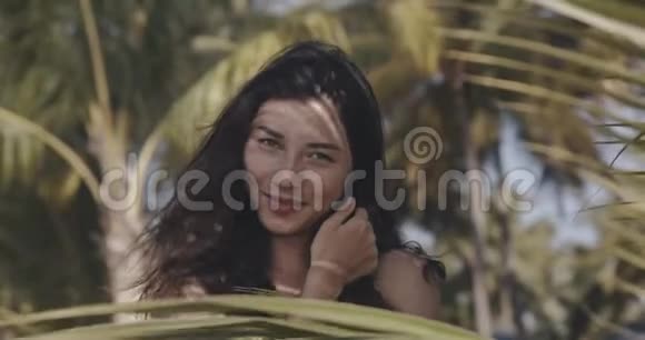 年轻美丽的女人的肖像完美光滑的皮肤在热带树叶天然化妆品的概念视频的预览图