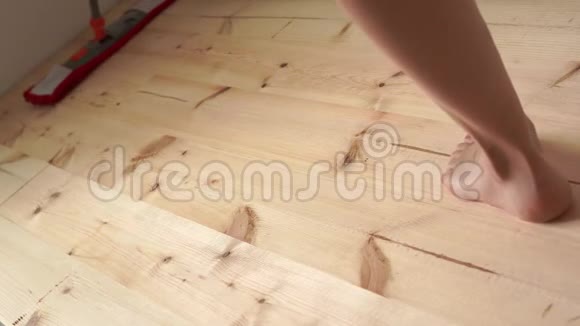 环保涂料打扫房子赤脚女人拖木地板视频的预览图