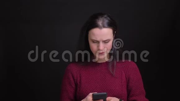 一幅成年白种人的特写肖像她在手机上发短信在镜头前开心地微笑着视频的预览图