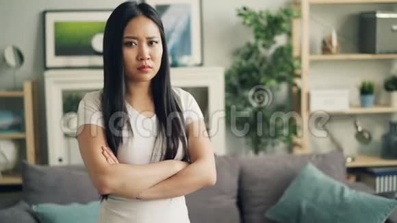 沮丧的亚洲女孩看着镜头悲伤的脸用手臂表达负面情绪的肖像视频的预览图