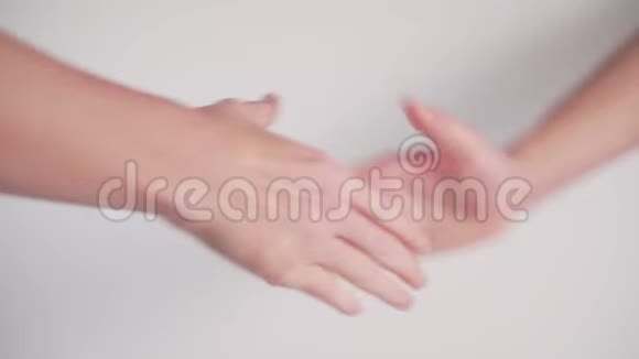 两个青少年在白色背景下握手视频的预览图