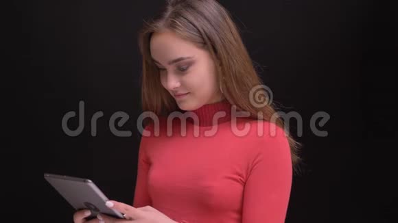 年轻美丽的白种人女性在手机上观看视频然后看着摄像机微笑着的特写照片视频的预览图
