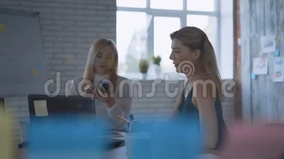 两个严肃的女人在现代办公室谈判电话会议视频的预览图