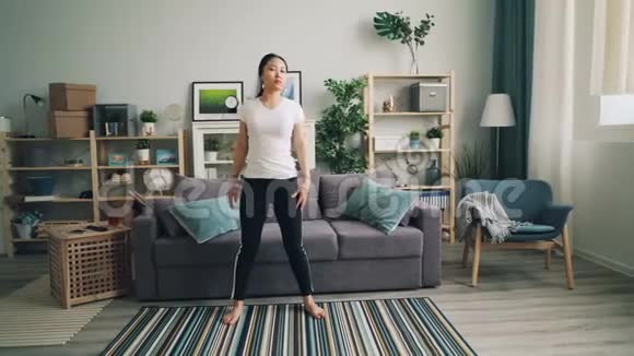 瘦削的亚洲女运动员在家做运动独自练习在个人活动中向左向右弯曲视频的预览图