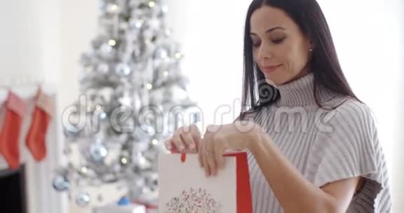 年轻女子打开圣诞礼包视频的预览图