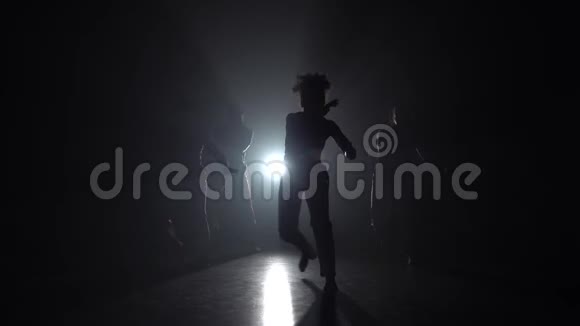 专业舞者在黑暗中练习卡波伊拉对抗演播室的聚光灯慢动作视频的预览图
