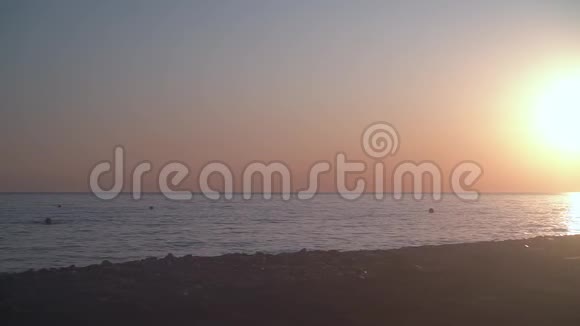 海岸上美丽的日落背景海滩的背景下夕阳越过地平线视频的预览图