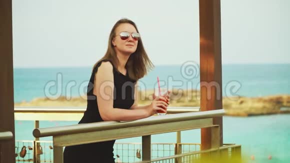 女人喝鸡尾酒在海边放松视频的预览图