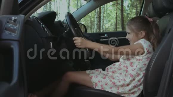 可爱的女孩假装开父母的车视频的预览图